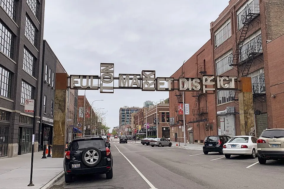 The Fulton Market District gateway sign over a West Loop street of brick warehouses